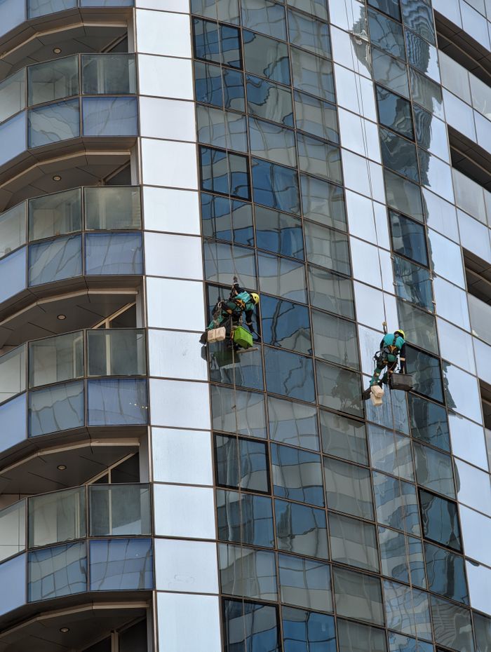gallery-01 Professional window cleaners working on a skyscraper in Abu Dhabi, showcasing urban architecture.